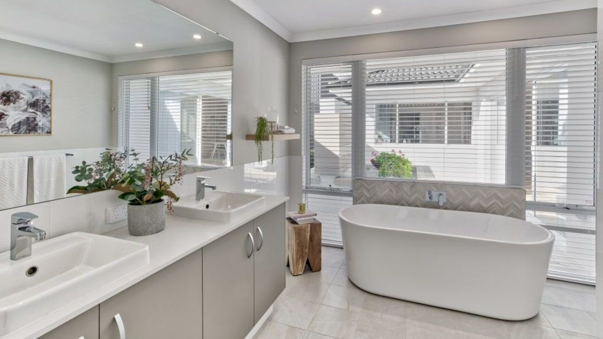 The Modern Bathroom Light grey bathroom with stand alone white bath near a panoramic window.