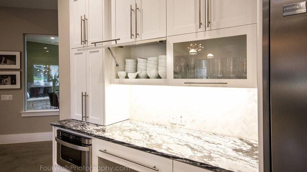 Kitchen cupboards and a table top made of black marble in the kitchen of Hobb's house